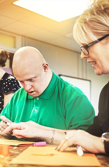 Person engaged in a creative activity with instructor support